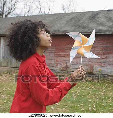 Girl blowing toy windmill View Large Photo Image Stock Photography - Girl blowing toy windmill. Fotosearch