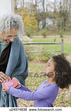 Stock Photo - Girl giving Valentine's card to woman. Fotosearch