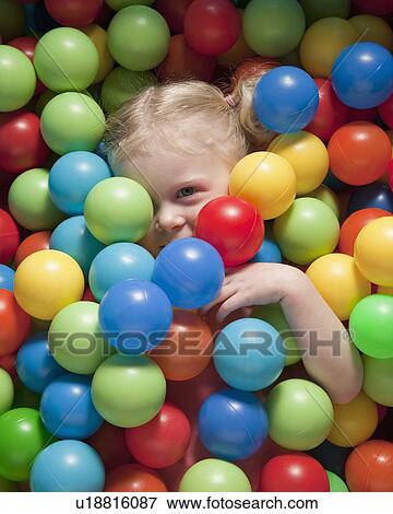Stock Photo - Girl hiding under balls. Fotosearch