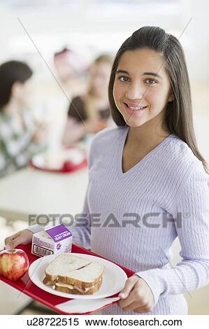 Stock Photography - Girl holding tray of cafeteria food. Fotosearch