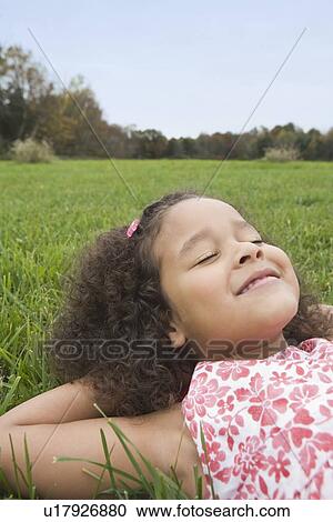 Stock Image - Girl lying on grass. Fotosearch