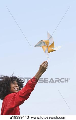 Girl playing with toy windmill View Large Photo Image Stock Image - Girl playing with toy windmill. Fotosearch