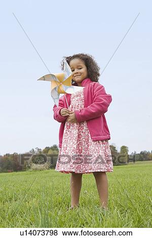 Stock Photo - Girl playing with toy windmill. Fotosearch