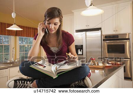 Girl sitting on kitchen counter View Large Photo Image Stock Image - Girl sitting on kitchen counter. Fotosearch