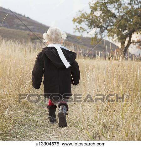 Girl walking in a meadow View Large Photo Image Stock Photograph - Girl walking in a meadow. Fotosearch