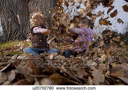 Girls playing in leaves View Large Photo Image Stock Image - Girls playing in leaves. Fotosearch