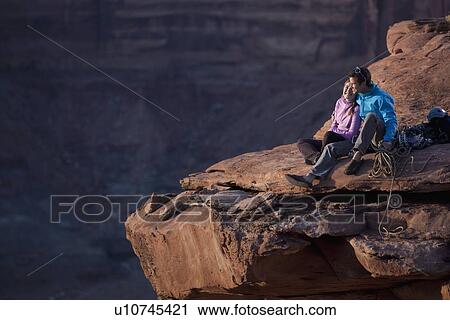Stock Image - Hikers at top of cliff. Fotosearch