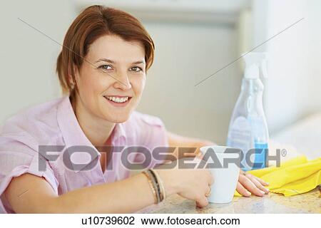Stock Image - House cleaner taking a break. Fotosearch