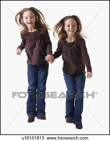 Stock Image - Identical twins jumping. Fotosearch