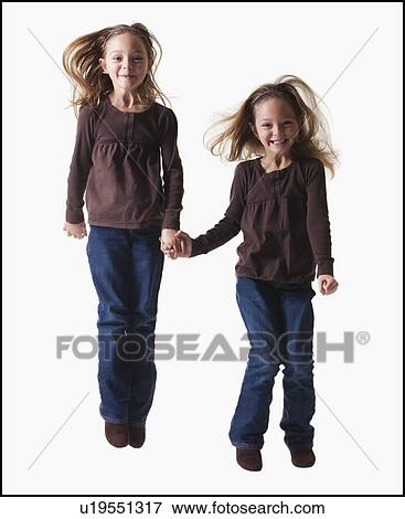 Identical twins jumping View Large Photo Image Stock Photo - Identical twins jumping. Fotosearch