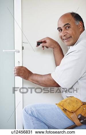 Man fixing door View Large Photo Image Stock Image - Man fixing door. Fotosearch
