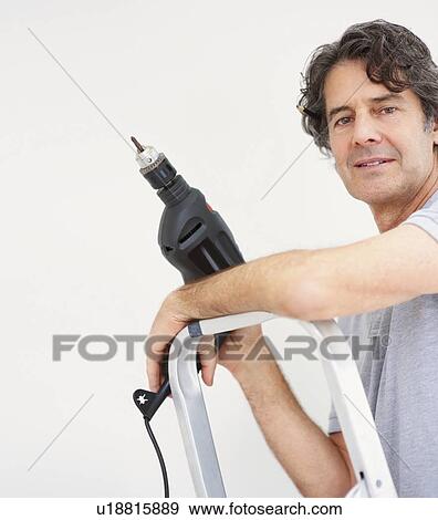 Man holding a drill View Large Photo Image Stock Photo - Man holding a drill. Fotosearch