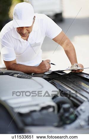 Man looking at car's engine View Large Photo Image Stock Image - Man looking at car's engine. Fotosearch
