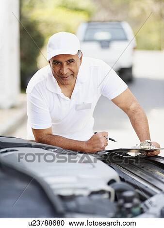 Man looking at car's engine View Large Photo Image Stock Image - Man looking at car's engine. Fotosearch