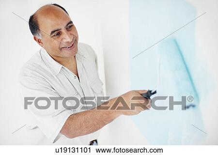 Stock Image - Man painting wall. Fotosearch