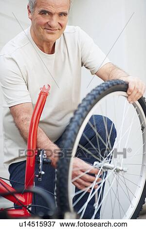 Stock Photo - Man repairing bicycle. Fotosearch