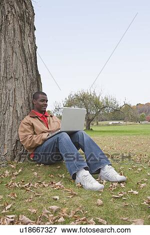 Man using laptop outside View Large Photo Image Stock Photo - Man using laptop outside. Fotosearch