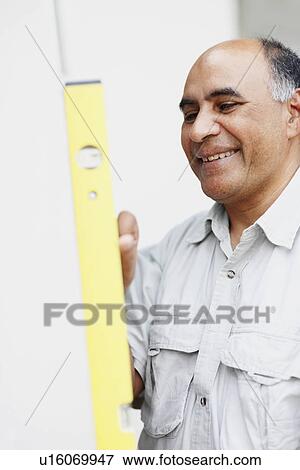 Stock Photo - Man using level. Fotosearch