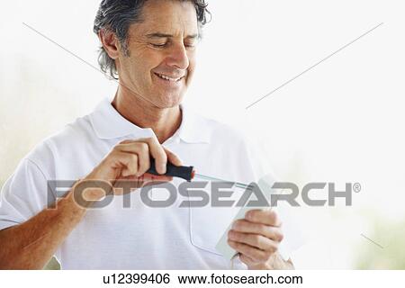 Stock Photograph - Man using screwdriver. Fotosearch