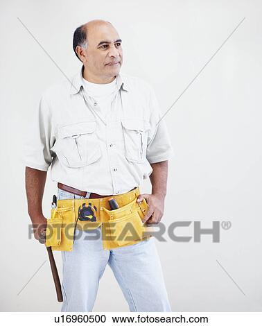 Stock Image - Man wearing tool belt. Fotosearch