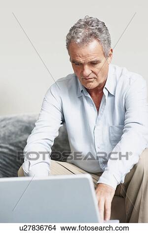 Picture - Man working on laptop. Fotosearch
