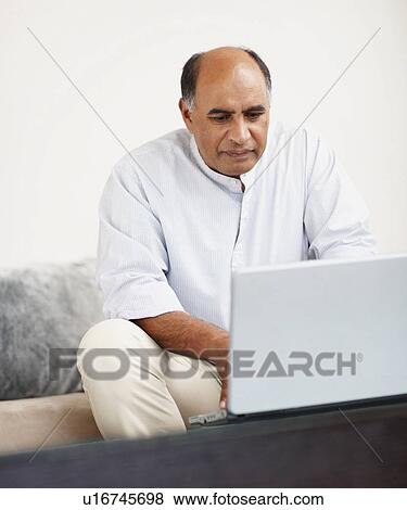 Stock Photo - Man working on laptop. Fotosearch