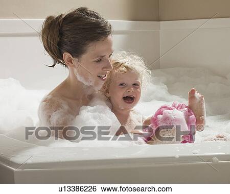 Stock Photograph - Mother and child having bubble bath. Fotosearch