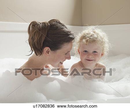 Stock Photograph - Mother and child having bubble bath. Fotosearch