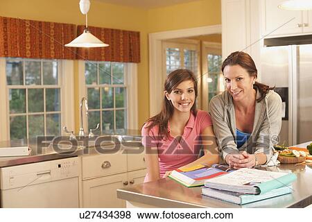 Stock Photo - Mother and daughter in kitchen. Fotosearch