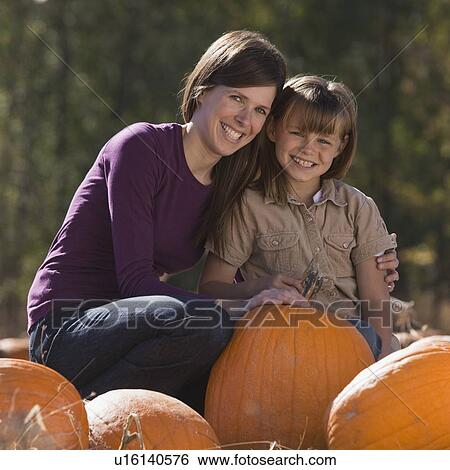 Mother and daughter in pumpkin patch View Large Photo Image Stock Photograph - Mother and daughter in pumpkin patch. Fotosearch