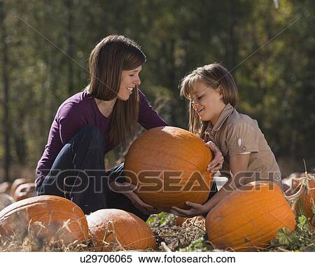 Stock Photography - Mother and daughter in pumpkin patch. Fotosearch