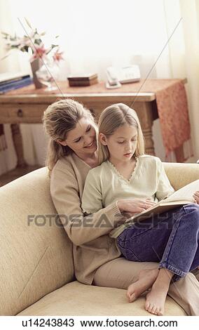 Stock Image - Mother and daughter reading a book. Fotosearch