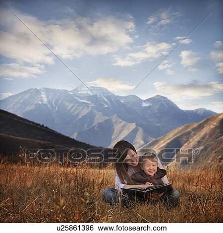 Stock Photograph - Mother and son reading outdoors. Fotosearch