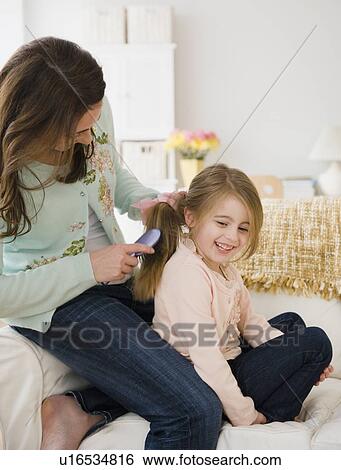 Stock Photograph - Mother brushing daughter's hair. Fotosearch