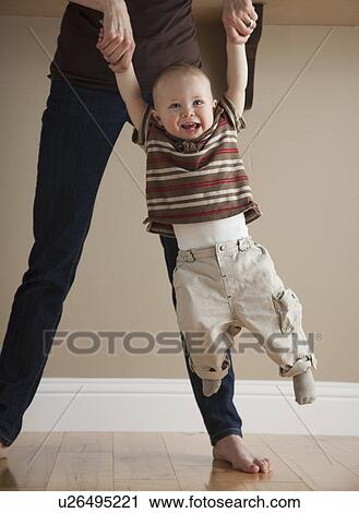 Stock Image - Mother swinging toddler. Fotosearch