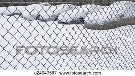 Stock Photo - Parking lot behind chain link fence. Fotosearch