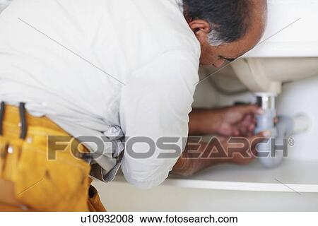 Plumber fixing sink View Large Photo Image Stock Photo - Plumber fixing sink. Fotosearch