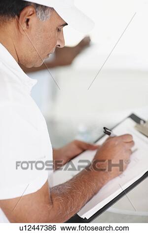 Stock Photograph - Repair person writing on clipboard. Fotosearch