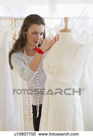 Stock Image - Seamstress in bridal shop. Fotosearch