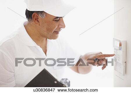 Stock Photo - Setting alarm. Fotosearch
