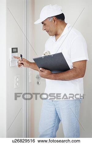 Stock Photograph - Setting alarm. Fotosearch