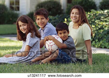 Stock Photo - Siblings sitting on the lawn. Fotosearch