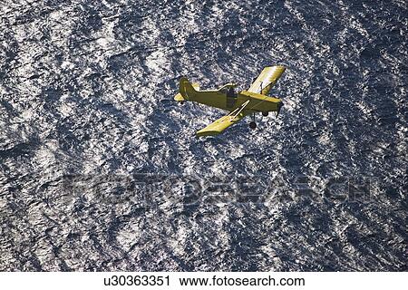 Small airplane ascending over water View Large Photo Image Stock Image - Small airplane ascending over water. Fotosearch