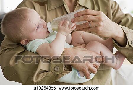 Stock Photography - Soldier Feeding baby a bottle. Fotosearch