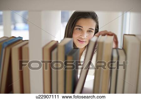Stock Image - Student selecting book. Fotosearch
