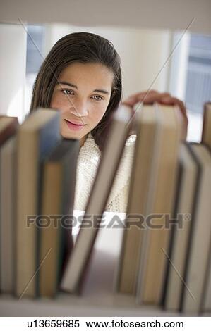 Stock Photography - Student selecting book. Fotosearch
