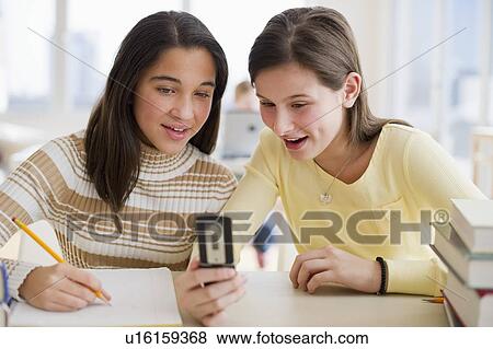 Stock Photo - Students looking at cell phone. Fotosearch