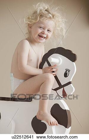 Stock Image - Toddler on rocking horse. Fotosearch