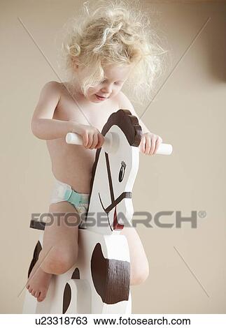 Stock Image - Toddler on rocking horse. Fotosearch