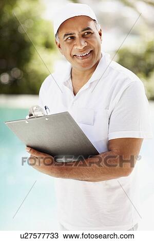 Stock Image - Tradesman writing on clipboard. Fotosearch
